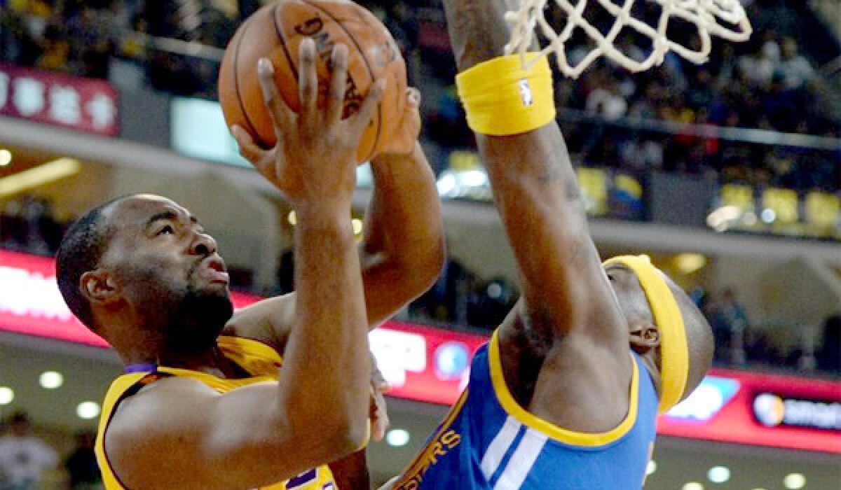 Marcus Landry is blocked by Jermaine O'Neal during a Lakers preseason exhibition against the Golden State Warriors in Beijing. Landry was waived by the team after Friday's 111-106 victory over the Utah Jazz.