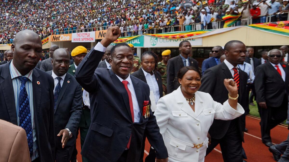 Emmerson Mnangagwa, center, and his wife, Auxillia, arrive at the presidential inauguration ceremony at the National Sport Stadium in Harare.