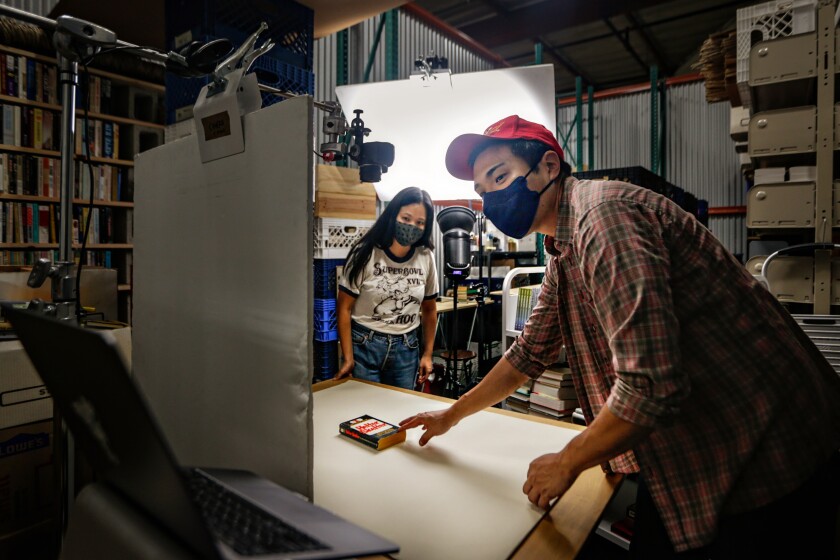  Chris Capizzi, and Jenny Yang, co-owners of A Good Used Book, photograph their new stock of books