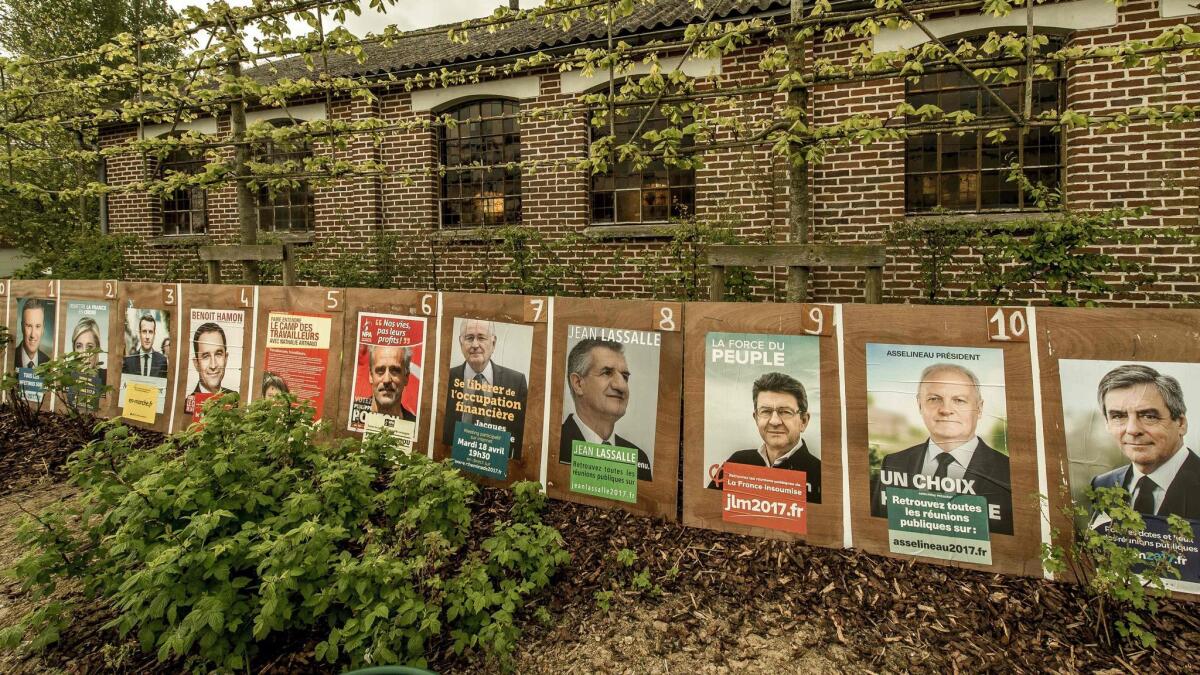 Campaign posters of French presidential candidates hang outside a church in Le Ryveld hamlet in Steenvoorde, northern France, on April 21, 2017.