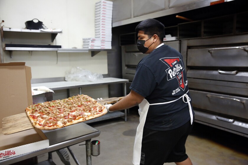 Ricardo Ramirez boxes up a big order for pickup at Petrillo's pizza parlor on Valley Boulevard in San Gabriel Valley. 