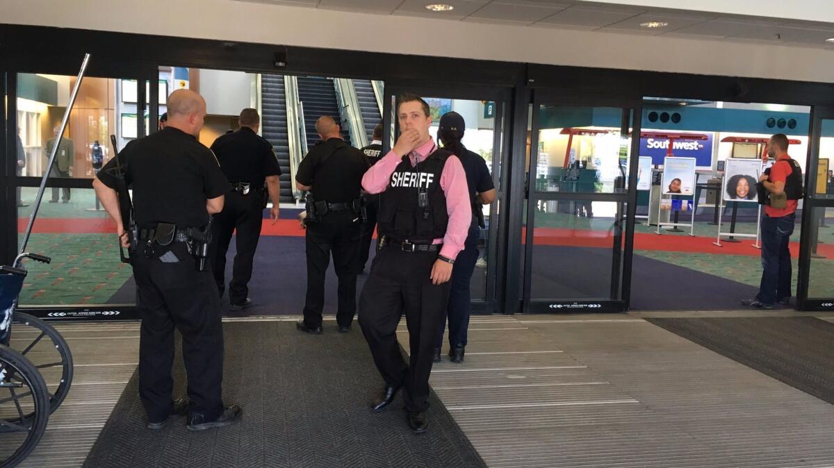 Authorities gather at a terminal at Bishop International Airport in Flint, Mich., where a police officer was attacked by a knife-wielding man Wednesday.