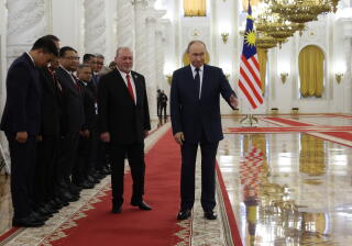 Russian President Vladimir Putin and King of Malaysia Sultan Ibrahim walk during a welcoming ceremony at the Kremlin