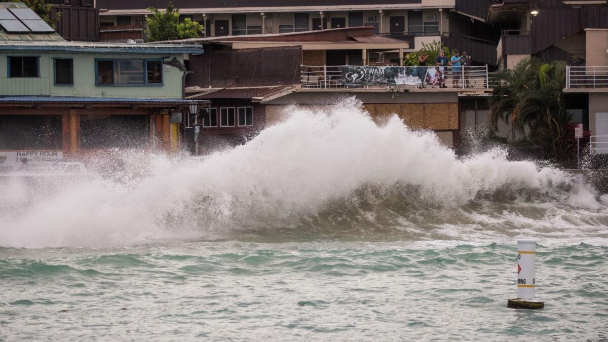 Visitors watch waves generated by Hurricane Lane crash at Kailua-Kona.