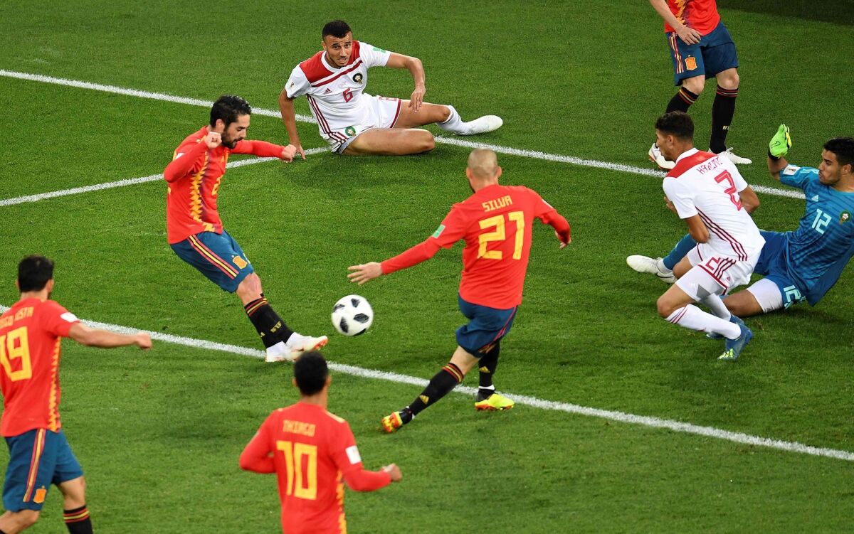 Spain's midfielder Isco (L) kicks to score their first goal during the Russia 2018 World Cup Group B football match between Spain and Morocco at the Kaliningrad Stadium in Kaliningrad on June 25, 2018.