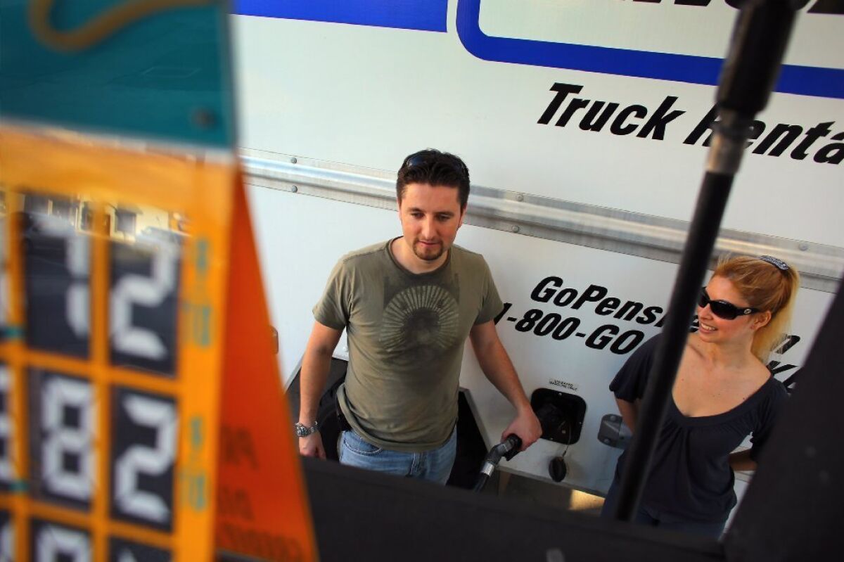Carlos Pena, left, and Claudia Pena fill their rental truck with gas in Miami. Fears of damage and theft prompt many Americans to move themselves.