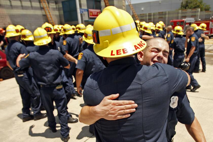 Daniel Balzano, right, gets a hug from Matthew LeBlanc as 58 recruits of the Los Angeles Fire Department celebrate following the recruit graduation ceremony on June 12. More than 10,000 applicants have applied for the next round of LAFD hiring.