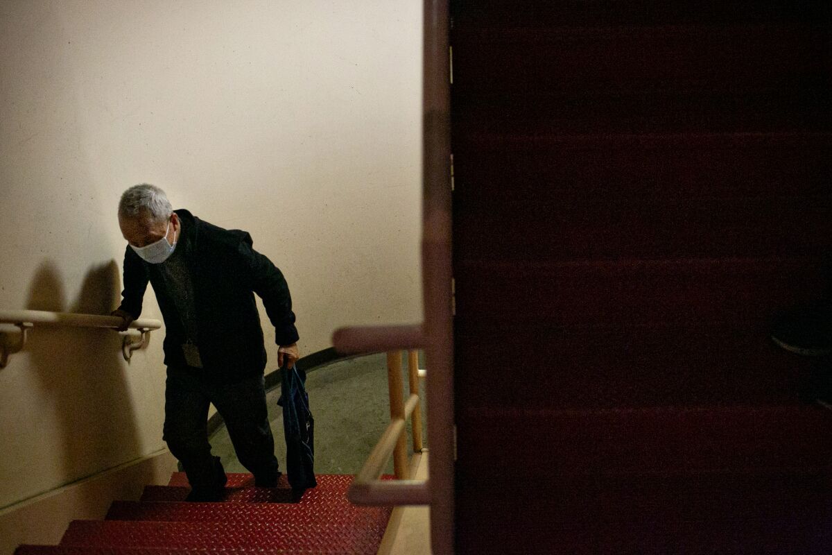 Wing Ng walks up the stairs to get to his apartment because the elevator at Cathay Manor is out of order.