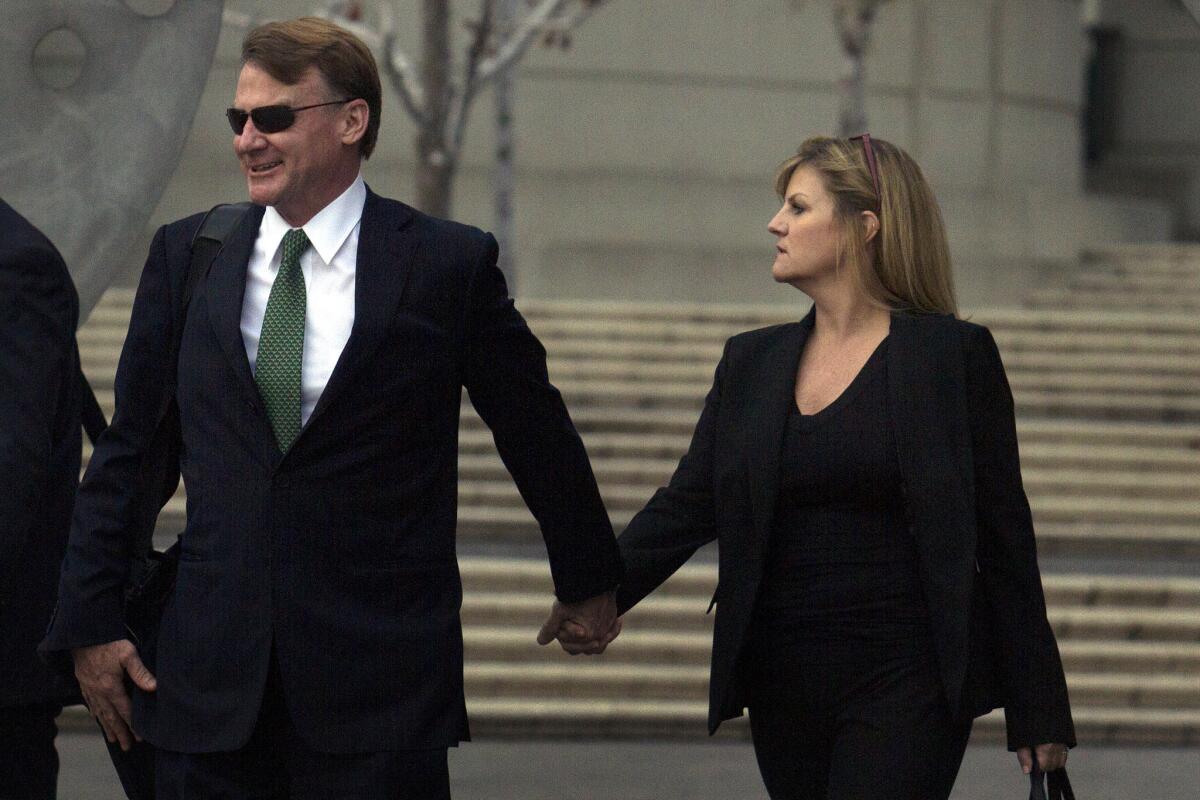 Brian Mulligan, left, leaves the Edward R. Roybal Federal Building on Tuesday after opening statements in Los Angeles.