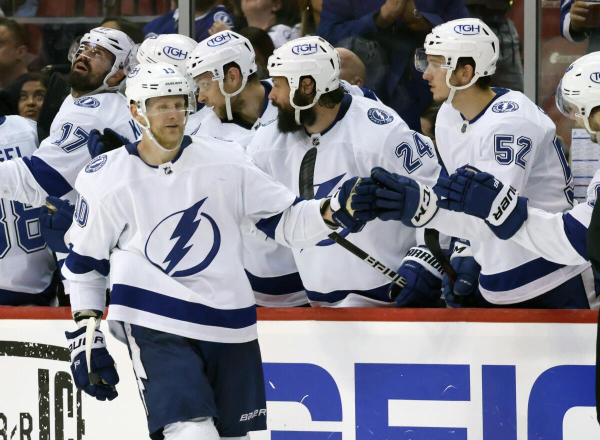Tampa Bay Lightning right wing Corey Perry (10) celebrates a goal against the Florida Panthers with defenseman Zach Bogosian (24) and defenseman Cal Foote (52) during the second period of Game 1 of an NHL hockey second-round playoff series Tuesday, May 17, 2022, in Sunrise, Fla. (AP Photo/Reinhold Matay)
