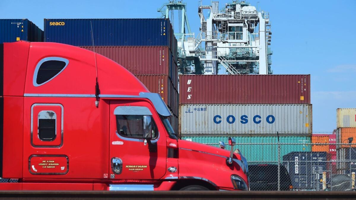 A delivery truck passes containers stacked at the Port of Long Beach, including one from COSCO, the Chinese state-owned shipping and logistics company. Trade talks between China and the United States this week yielded little visible progress toward a cease-fire.