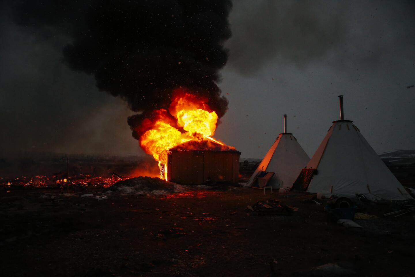 Campers set structures on fire in preparation of the Army Corps of Engineers' deadline to leave the Oceti Sakowin protest camp in Cannon Ball, N.D. Activists and protesters have occupied the Standing Rock Sioux reservation for months in opposotion to the completion of the Dakota Access Pipeline.