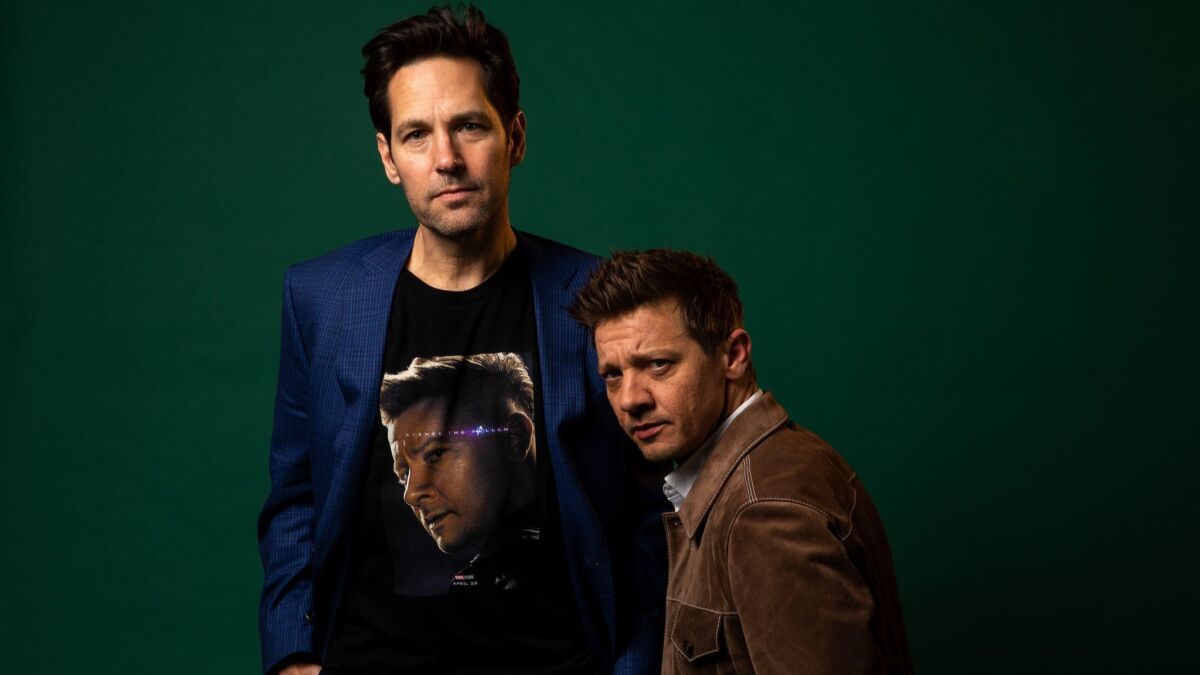 Jeremy Renner, right, poses next to his own face, on a T-shirt worn by his "Avengers: Endgame" costar Paul Rudd.