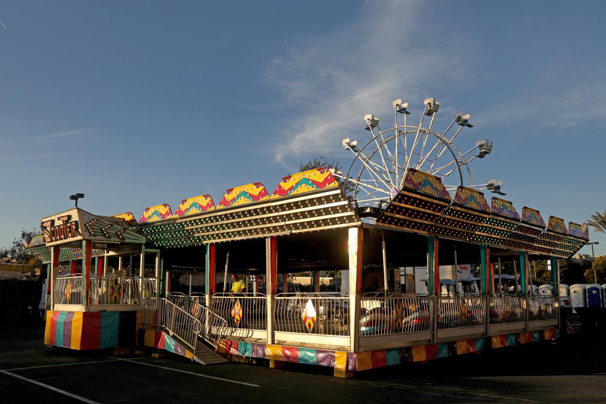 Carnival bumper car setup with a ferris wheel in the background