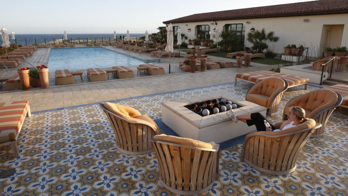A woman relaxes by the fire pit at the Terranea Spa, at Terranea resort in Rancho Palos Verdes. Union workers collected enough signatures for a ballot measure to require the resort and the nearby Trump National Golf Club to provide panic buttons for workers.