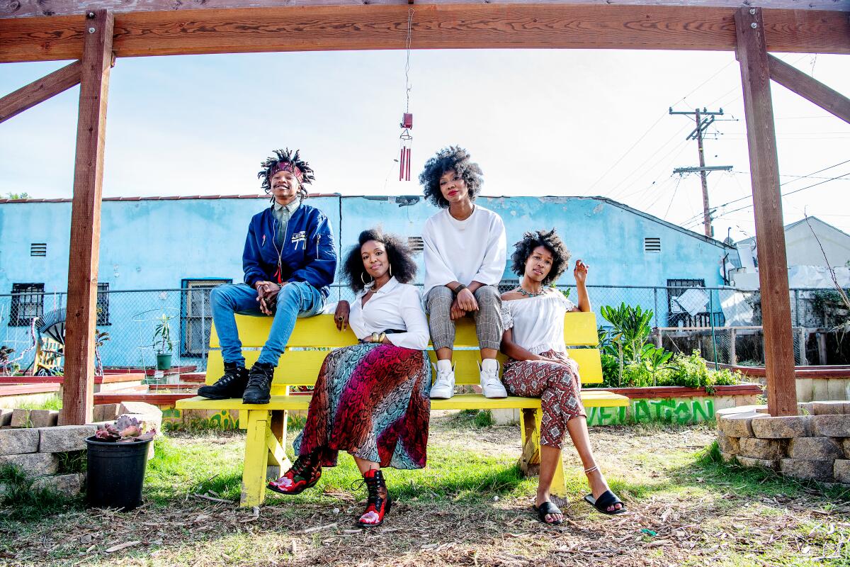 Temu Asyr Bey, Kara Still, Carmen Dianne and Keira Adams sit on a yellow bench.