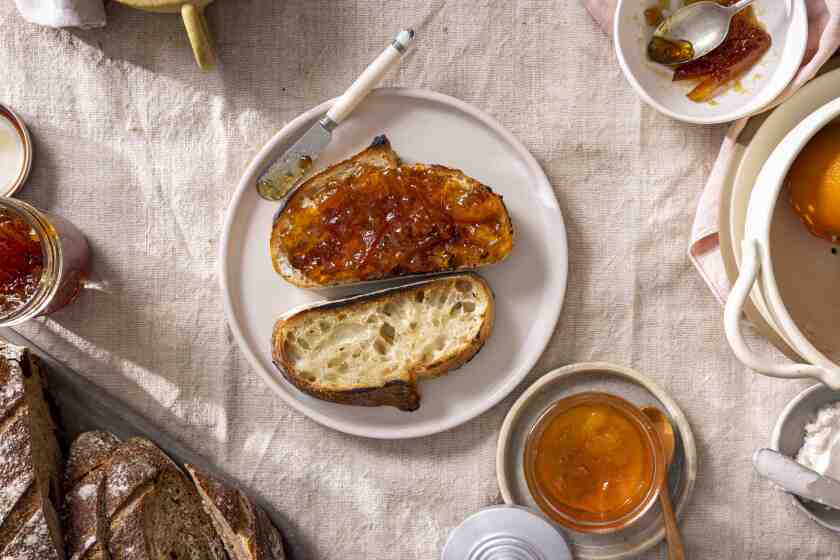 LOS ANGELES, CALIFORNIA, Jan. 19, 2022: (L) Oro-Blanco grapefruit marmalade in a jar and Seville-orage marmalade served on bread and butter, photographed for the January "LA in A Jar" story by Ben Mims, on Wednesday, January 18, 2022, at Proplink Studios in the Arts District in Downtown Los Angeles. (Silvia Razgova / For The Times, Prop Styling / Jennifer Sacks, Photo Assistant / Olliver Leighton)