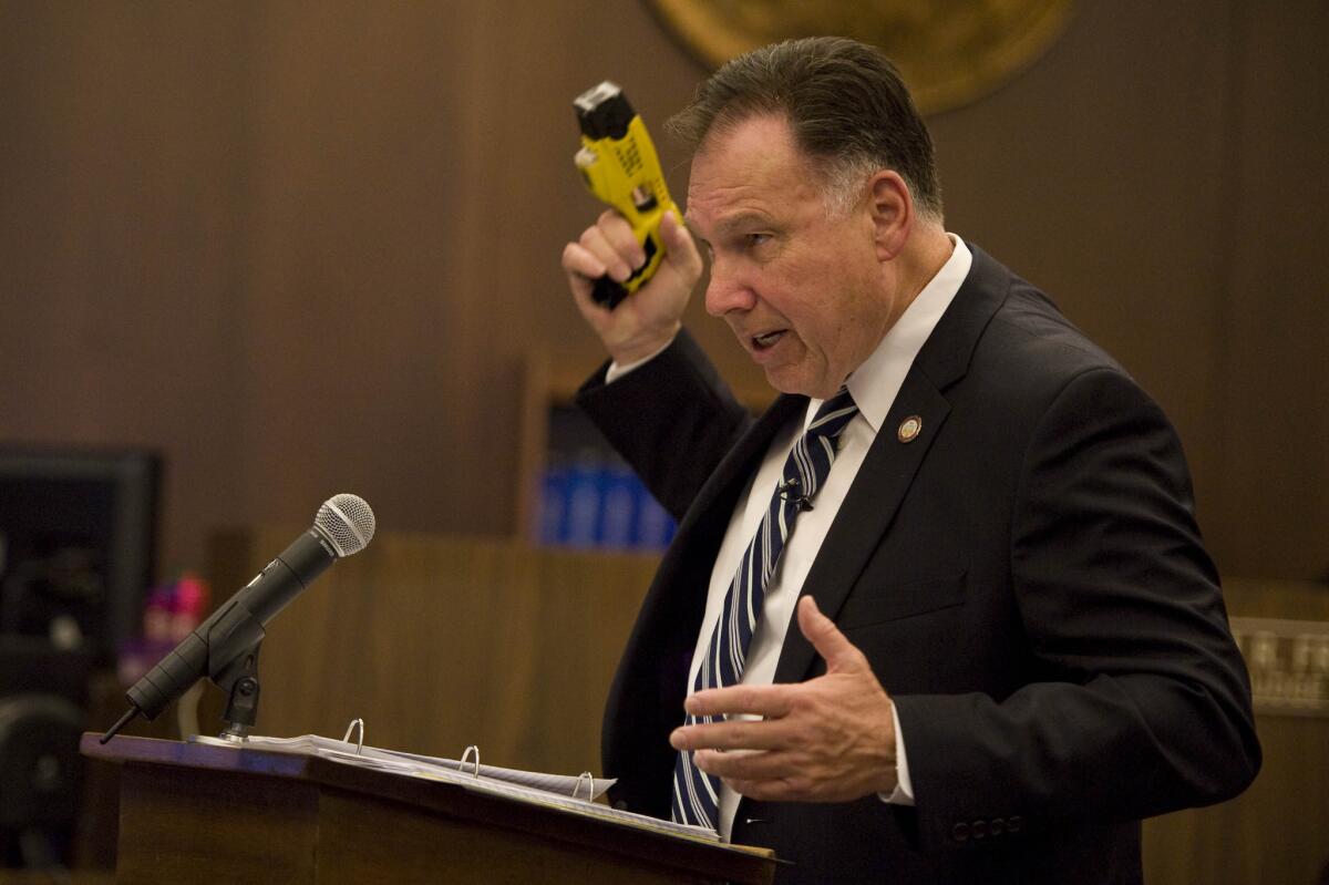 Orange County District Attorney Tony Rackauckas holds up a stun gun similar to the one used to beat Kelly Thomas.