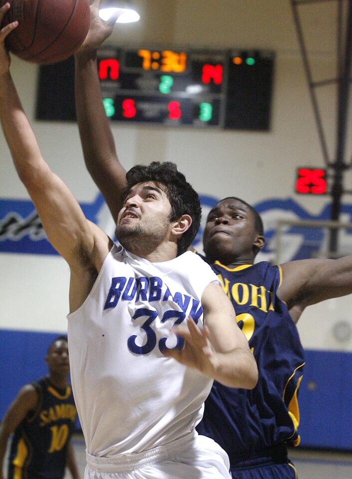 Burbank's Sarkis Karian beats the defense of Santa Monica's Chris Smith for a layup in the second quarter in a CIF Southern Section Division I-A second-round boys basketball playoff game at Burbank High School on Tuesday, February 19, 2013.