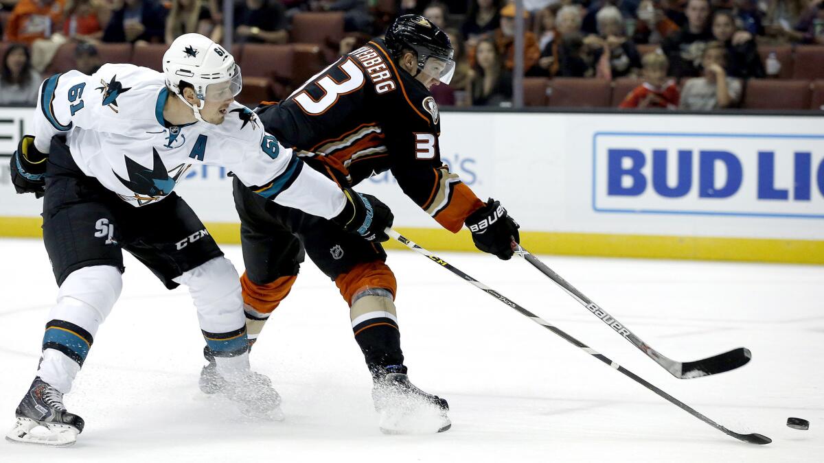 Ducks winger Jakob Silfverberg flips a shot on goal while under pressure from Sharks defenseman Justin Braun during the second period Sunday.
