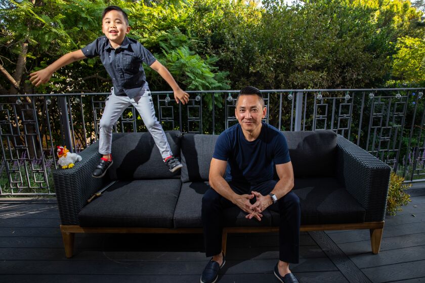 PASADENA, CA - OCTOBER 20: Pulitzer Prize-winning author Viet Thanh Nguyen is photographed with his son Ellison, in the backyard, of their Pasadena, CA, home, Tuesday, Oct. 20, 2020. The duo wrote a children's book together, "Chicken of the Sea," and will take part in the Los Angele Times Festival of Books. (Jay L. Clendenin / Los Angeles Times)