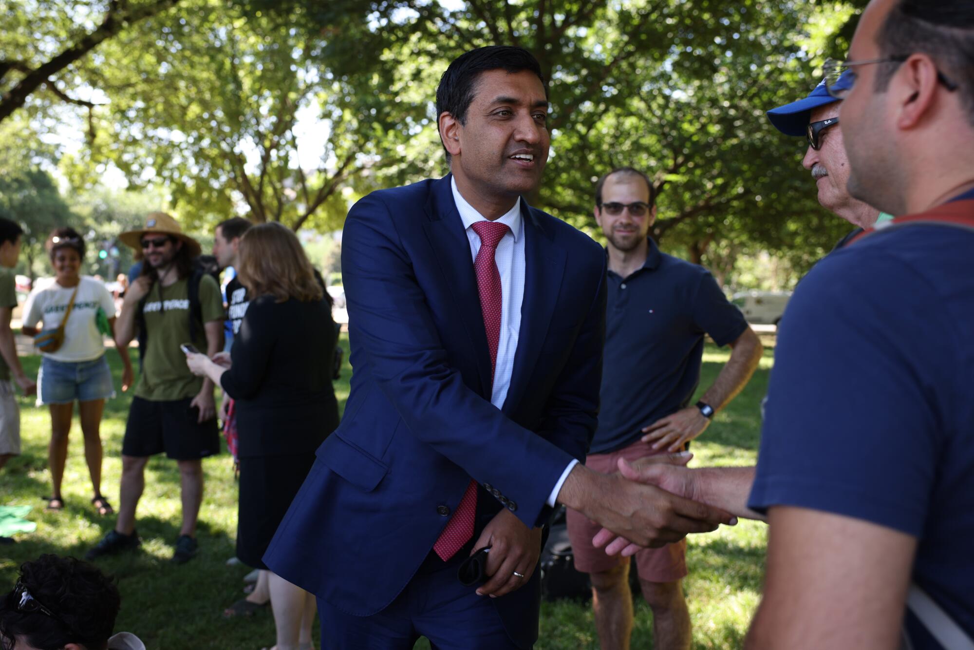 Rep. Ro Khanna shakes a man's hand at an outside rally 