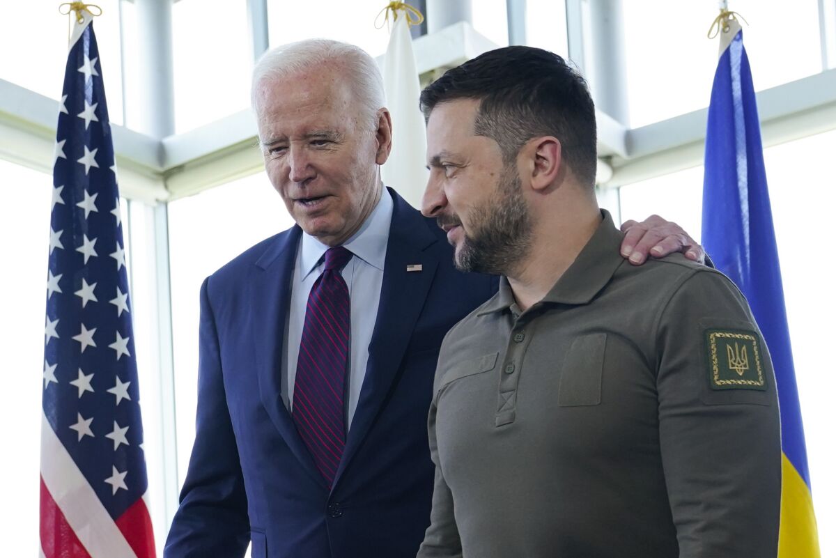 President Biden stands with an arm around Ukrainian President Volodymyr Zelensky's shoulder.