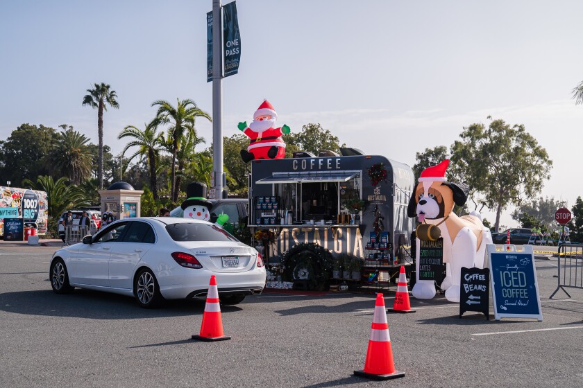 A car drives past a Nostalgia Coffee Roasters stand at the Taste of December Nights on Saturday in Balboa Park.