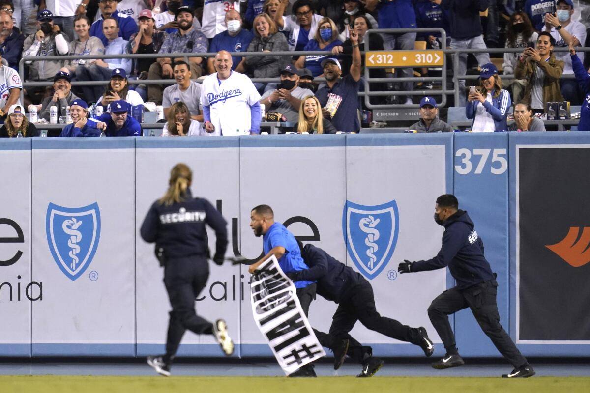 Protester Edin Enamorado, holding a banner with the name of the La Loma neighborhood, is tackled by security Sept. 15.