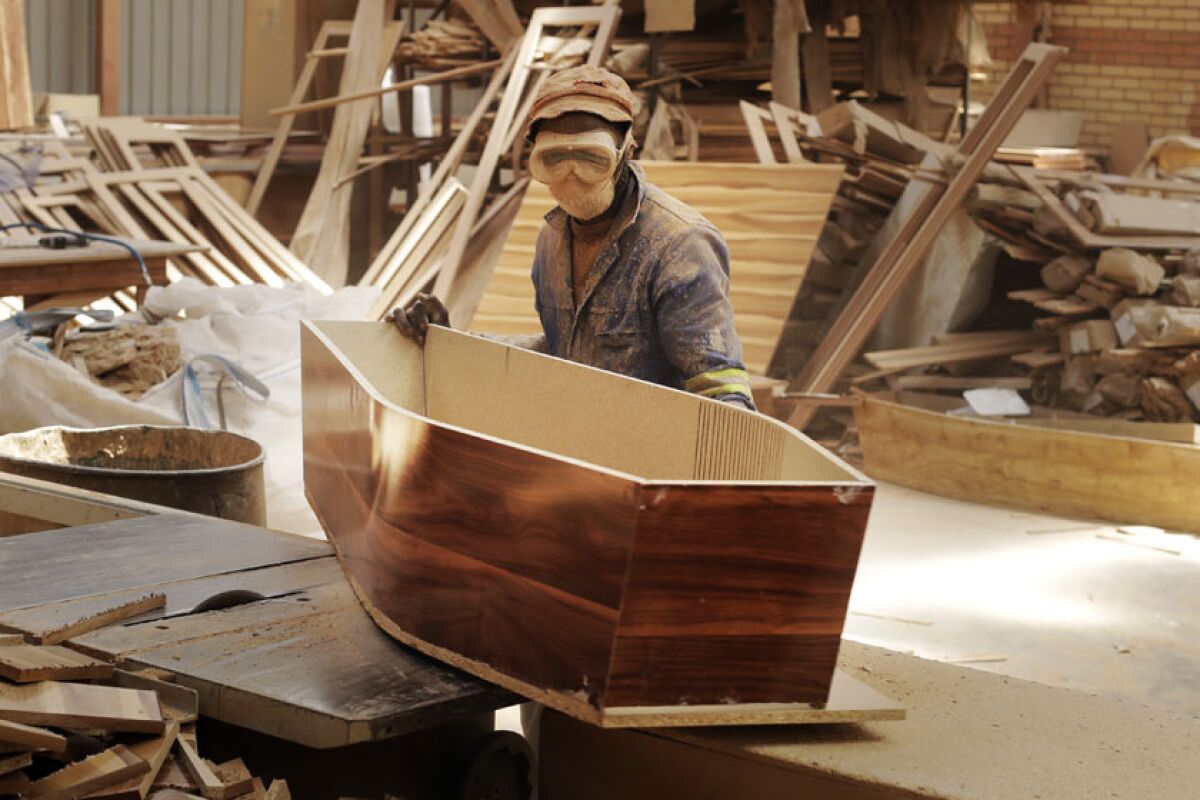 A worker constructs coffins at a Johannesburg shop.