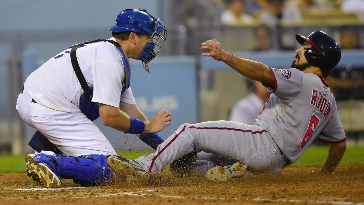 Dodgers catcher A.J. Ellis, left, tags out Washington Nationals baserunner Anthony Rendon at home plate during the seventh inning of the Dodgers' 6-4 loss Monday.