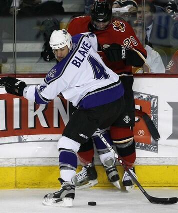 Los Angeles Kings Rob Blake, left, looks for the puck after checking Calgary Flames Kristian Huselius.