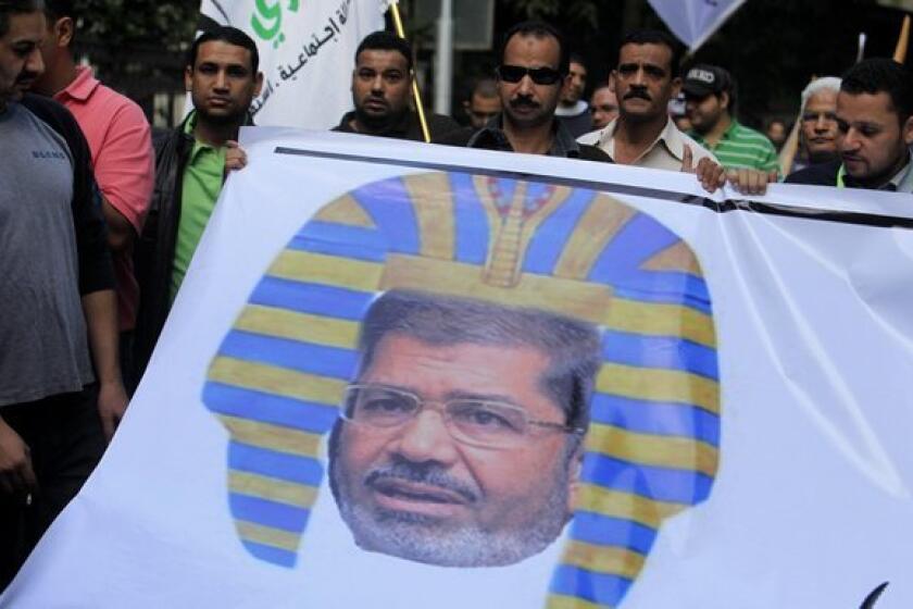 Egyptian protesters hold a banner depicting Egyptian President Morsi as a pharaoh in Cairo. Last week Morsi announced that his rule was immune to judicial oversight of any kind.