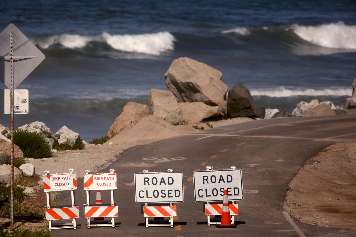 Waves are minus surfers next to a closed bike path in Manhattan Beach.