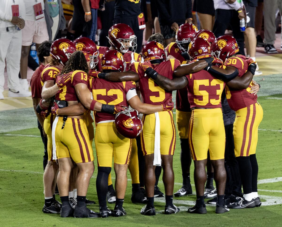 The USC defense huddles together on the field before playing Arizona at the Coliseum on Oct. 7.
