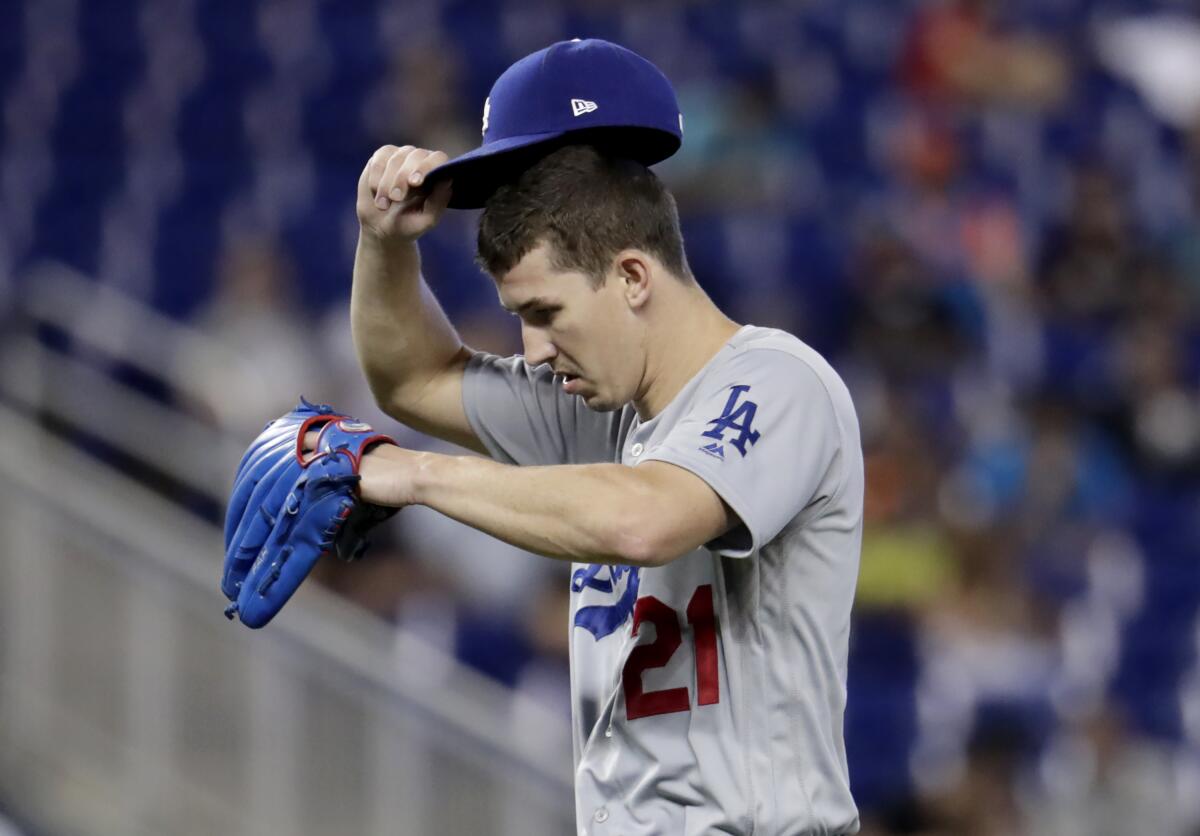 Dodgers starting pitcher Walker Buehler adjusts his cap after walking Miami Marlins' Isan Diaz during the fourth inning on Thursday in Miami. 