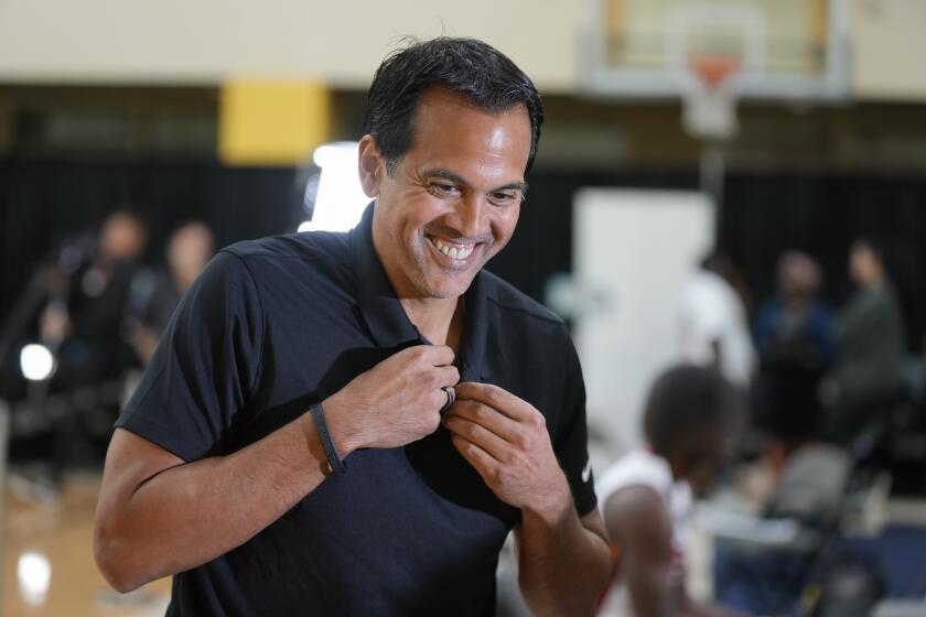 Miami Heat head coach Erik Spoelstra removes a mic following an interview during the NBA basketball team's media day, in Miami, Monday, Oct. 2, 2023. (AP Photo/Rebecca Blackwell)