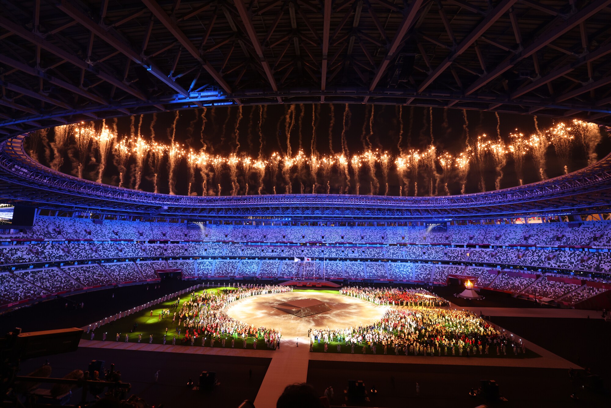 A long-range view of the interior of the stadium, with spectator seats bathed in blue light.