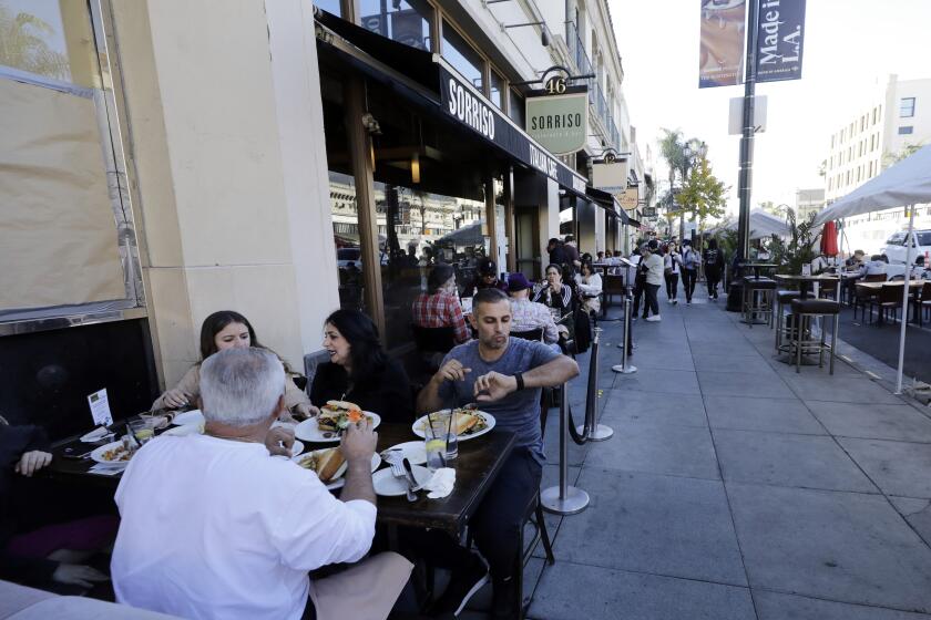 PASADENA, CA - NOVEMBER 29: Visitors to Old Pasadena dine outdoors along Colorado Boulevard on Sunday, Nov. 29, 2020. Unlike Los Angeles County, Pasadena, with its own health department, is still allowing outdoor patio dining. Residents and visitors are still urged to follow COVID-19 safety protocols. (Myung J. Chun / Los Angeles Times)
