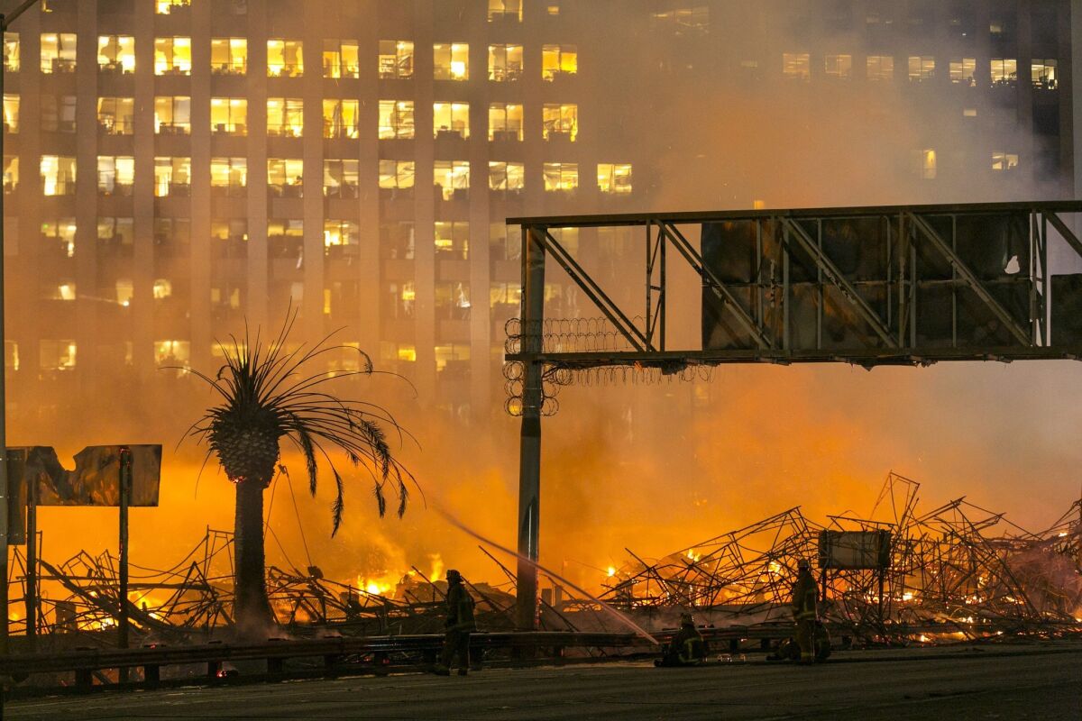 Los Angeles firefighters battle the blaze at the Da Vinci apartments in downtown Los Angeles in January. The developer behind the complex addressed criticisms of the buildings in a new interview.