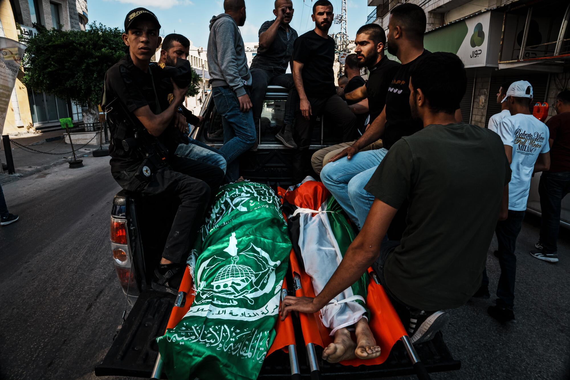 Mourners transport the 9 bodies of slain Palestinians during a funeral procession.
