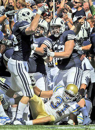 Defensive end Brett Denney celebrates with Brigham Young teammates after recovering a fumble by UCLA fullback Trevor Theriot in the second quarter Saturday.