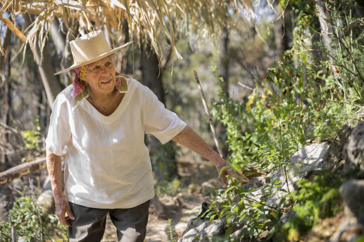 Diana Kennedy looks among plants and trees