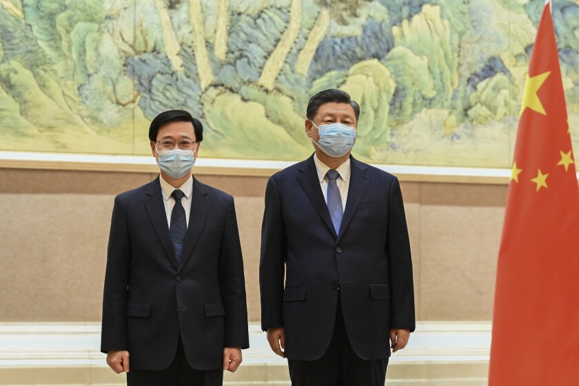 FILE - In this photo released by Xinhua News Agency, Chinese President Xi Jinping, right, and Hong Kong Chief Executive-elect John Lee pose for photo before their meeting in Beijing, on May 30, 2022. Hong Kong’s police force on Tuesday, June 28, 2022, confirmed that Chinese president Xi Jinping will visit the city for the 25th anniversary of the former British colony’s return to Chinese rule. (Li Xueren/Xinhua via AP, File)