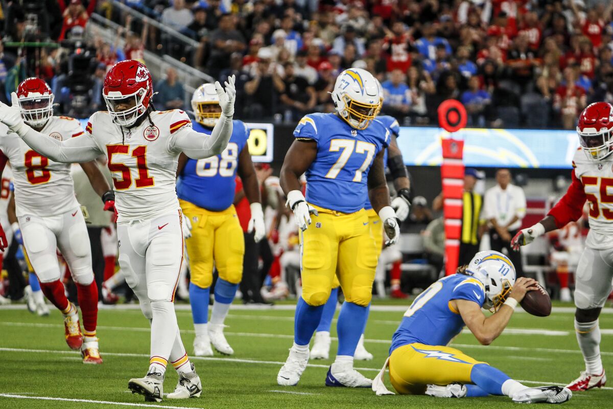 The Chargers' Justin Herbert (10) shows frustration after being sacked by the Chiefs' Mike Danna (51).