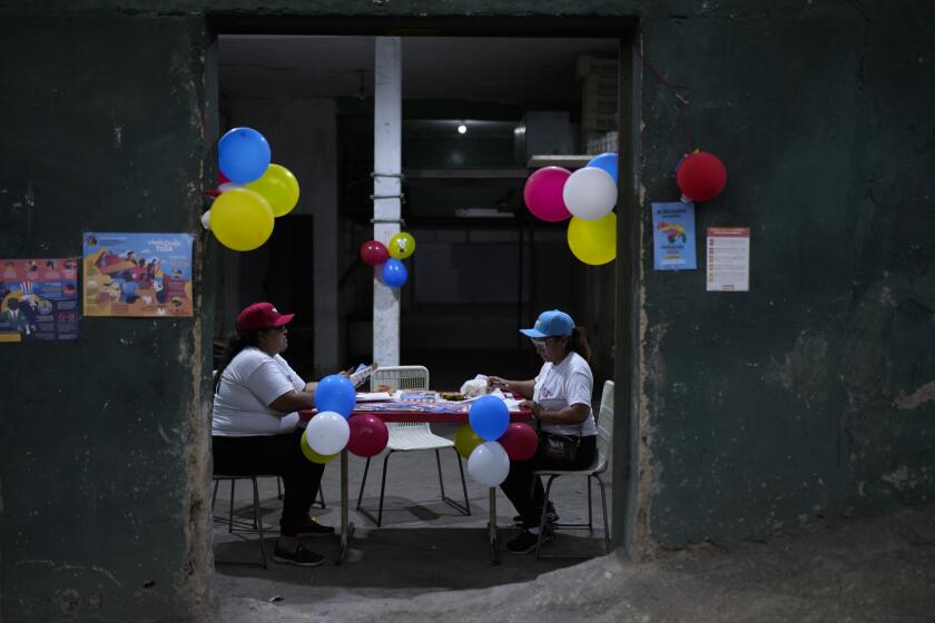Organizadores de base del partido gobernante, conocidos como "líderes comunitarios", preparan documentos y propaganda sobre la región de Esequibo, durante un referéndum sobre el futuro de un territorio en disputa con Guyana, en Caracas, Venezuela, el 3 de diciembre de 2023. (AP Foto/Ariana Cubillos)
