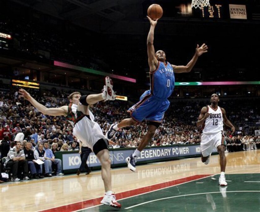 Milwaukee Bucks' Luke Ridnour, left, fouls Oklahoma City Thunder's Russell Westbrook, right, in the first half of an NBA basketball game Saturday, April 11, 2009, in Milwaukee. (AP Photo/Darren Hauck)