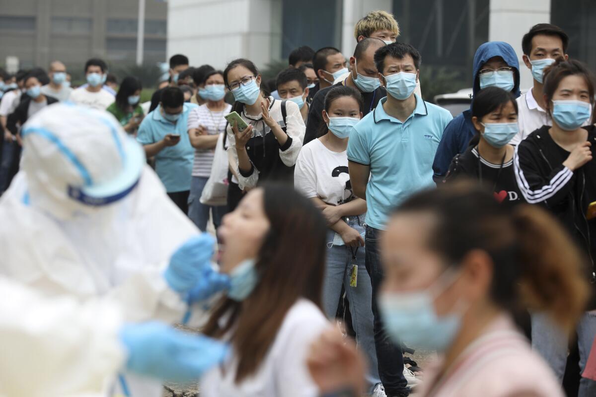 People line up for coronavirus testing at a large factory in Wuhan, China.