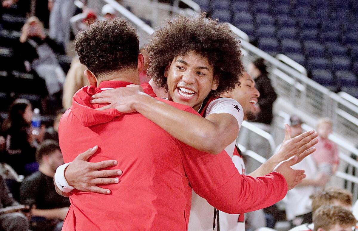 Robert Hinton gets a celebratory hug after scoring 15 points in Harvard-Westlake's 54-47 Open Division championship win.