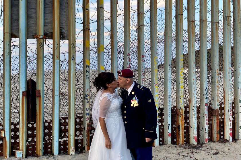 Yolanda Varona, directora de DREAMers Moms en Tijuana y Héctor Barajas, fundador del grupo de Veteranos Deportados en Tijuana celebraron ceremonia religiosa frente al muro fronterizo